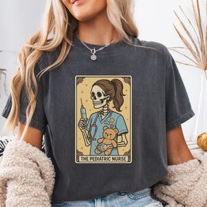 Pädiatrische Krankenschwester Shirt, Comfort Colors® Skeleton Tarot-Karte T-Shirt, lustiges Halloween RN Geschenk, NICU Krankenschwester Ästhetisches Shirt mit Spritze und Bär