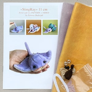 Op de afbeelding: Een knutselpakket voor een 11 cm StingRay knuffel van Tetiana Skalozub, inclusief een geprint patroon en video, een paarse pluche pijlstaartrog, vellen gele en lichtpaarse stof, kleine kraaltjes, donker garen en witte pijpenragers.