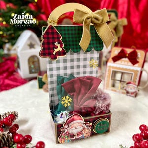 Può includere: Un sacchetto regalo natalizio decorativo con manico e fiocco dorati. La borsa presenta un design ad albero di Natale e renna a quadri rossi e neri. La borsa è piena di oggetti rossi e verdi e il fondo ha un'illustrazione di Babbo Natale.