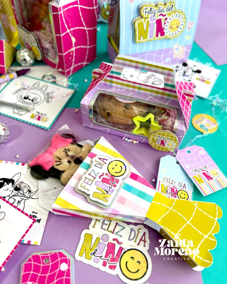 Peut inclure: Une collection de bo&icirc;tes cadeaux, d'&eacute;tiquettes et d'autocollants color&eacute;s avec le texte "Feliz D&iacute;a del Ni&ntilde;o" et des visages souriants. Les bo&icirc;tes contiennent des biscuits et d'autres friandises. La palette de couleurs comprend le rose, le jaune et le violet.