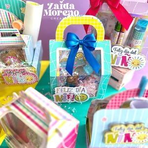 Peut inclure: Plusieurs coffrets cadeaux aux motifs color&eacute;s, dont une bo&icirc;te turquoise avec un n&oelig;ud bleu et une poign&eacute;e jaune. Les bo&icirc;tes contiennent des friandises et de petits jouets, avec le texte "Feliz d&iacute;a del Ni&ntilde;o" sur des autocollants. L'arri&egrave;re-plan est un m&eacute;lange de violet et de vert.