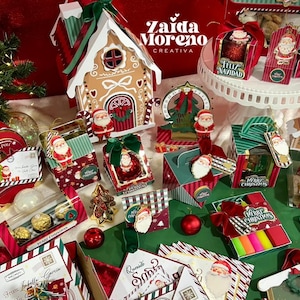 Puede incluir: Una exhibición festiva de cajas de regalo y decoraciones navideñas. La escena incluye una casa de jengibre, figuras de Papá Noel y cajas con patrones rojos, verdes y blancos. El texto "Zaida Moreno Creativa" es visible.