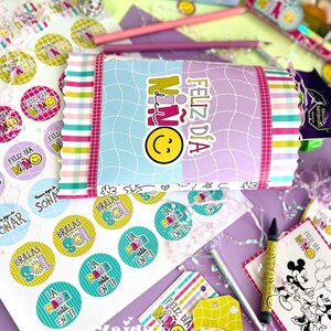 Peut inclure: Une collection de papeterie et d'articles cadeaux color&eacute;s, comprenant des autocollants, des &eacute;tiquettes et un paquet emball&eacute;. Les articles pr&eacute;sentent le texte "Feliz D&iacute;a Ni&ntilde;o" et des graphiques de smiley. Des crayons et d'autres &eacute;l&eacute;ments d&eacute;coratifs sont &eacute;galement visibles.