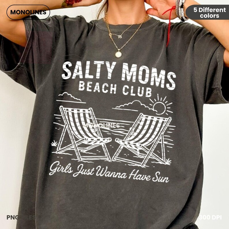 May include: A dark grey t-shirt with white text that reads "Salty Moms Beach Club" and "Girls Just Wanna Have Sun". The design includes two beach chairs and a sun.