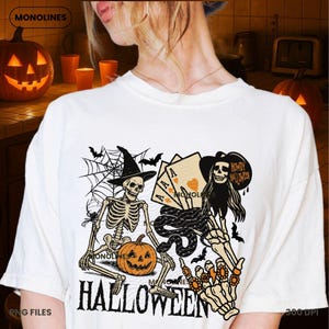 May include: Off-white Halloween-themed t-shirt featuring a graphic of two skeletons, a jack-o'-lantern, playing cards, and bats. The text "HALLOWEEN" is printed in large, bold letters at the bottom of the shirt. The design includes a spider web and a witch's hat.