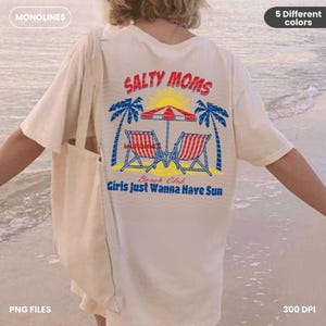 K&ouml;nnte beinhalten: Ein wei&szlig;es T-Shirt mit einem grafischen Design einer Strandszene mit Palmen, Strandst&uuml;hlen und einem Sonnenschirm. Der Text "SALTY MOMS" befindet sich &uuml;ber der Szene, und der Text "Beach Club Girls Just Wanna Have Sun" befindet sich unter der Szene.
