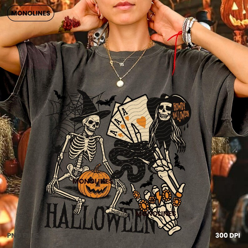 May include: Dark gray Halloween-themed t-shirt with a distressed graphic. The design features skeletons, a jack-o'-lantern, playing cards, bats, and the word "HALLOWEEN". The shirt has a vintage, worn look.