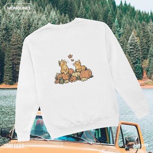 Cute kitten fall clipart with pumpkins and maple leaves in warm autumn colors, printable Fall Cat PNG for seasonal shirts and gifts.