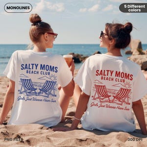 May include: Two white t-shirts with a graphic design of beach chairs and the text "Salty Moms Beach Club" and "Girls Just Wanna Have Sun".