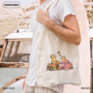 Cute autumn cat clipart with pumpkins and falling leaves designed for seasonal shirts, sweatshirts and DIY crafts.