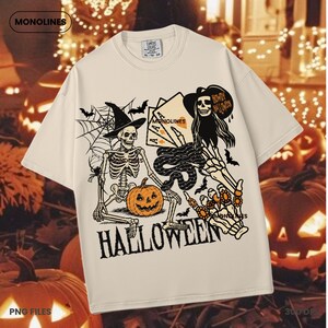 May include: Cream-colored t-shirt with a Halloween-themed graphic. The design features a skeleton wearing a witch hat, a jack-o'-lantern, playing cards, bats, and the word "HALLOWEEN".