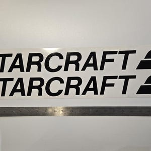 May include: Two black vinyl decals with the text "Starcraft" and a stylized wing design.
