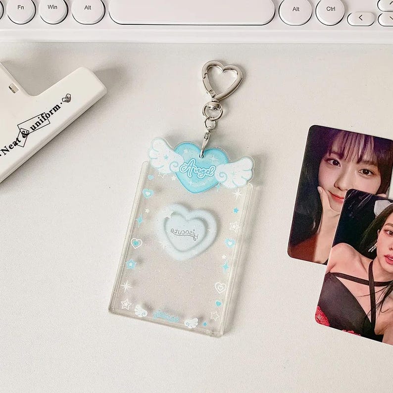 Pu&ograve; includere: Un portachiavi in plastica trasparente con un cuore blu e ali. Il cuore ha la scritta "Angel" su di esso. Il portachiavi ha un anello di metallo argentato.