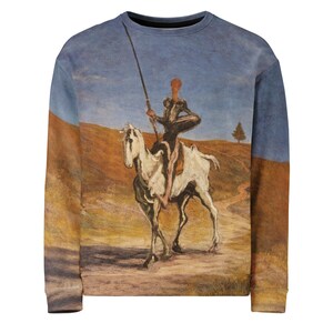 May include: Crew neck sweatshirt featuring a painting of a knight on horseback, holding a lance. The artwork depicts a figure in armor riding a white horse against a landscape of brown hills and a blue sky. The sweatshirt has a vintage look.