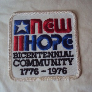 Può includere: Toppa ricamata bianca con una stella rosso, bianco e blu e il testo "New Hope Bicentennial Community 1776 - 1976".