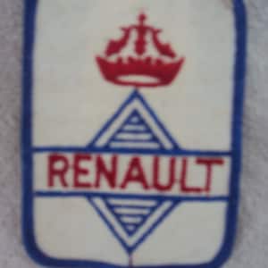 Op de afbeelding: Een witte geborduurde patch met een blauwe rand. De patch heeft een rode kroon en een blauwe diamant met het woord "RENAULT" in rode letters.