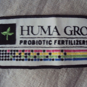 May include: White patch with black border, featuring a green plant logo and the text "HUMA GRO PROBIOTIC FERTILIZERS".