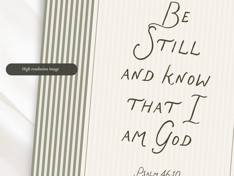 May include: A cream-colored print with the words "Be Still and Know That I Am God" in elegant script. The text is in dark brown, with "Psalm 46:10" at the bottom. A section with vertical stripes in olive green and white is on the left.