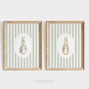 Può includere: Due stampe incorniciate con uno sfondo a strisce verde e bianco. Ogni stampa presenta un cerchio con un'illustrazione ad acquerello di un coniglio marrone che indossa una giacca verde. Il testo "GARDEN of GRACE TIMELESS WALL ART" è stampato sotto le cornici.