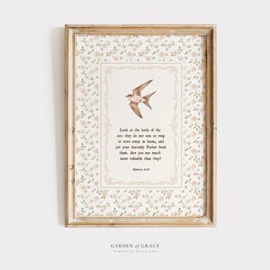 May include: Framed wall art featuring a watercolor illustration of a bird in flight, centered on a cream-colored background with text. The frame is a light brown color, and the background has a floral pattern. The text reads, "Look at the birds..."