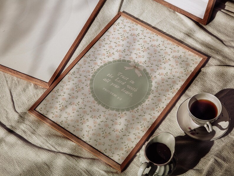 Op de afbeelding: Houten ingelijste print met bloemenpatroon en de tekst "Trust in the Lord with all your heart." Een kopje thee en melk staan ernaast. De print is 30x40 cm.
