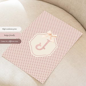 Puede incluir: Una impresi&oacute;n rosa estampada con un marco decorativo con la letra "J" y un lazo. La impresi&oacute;n tiene el texto "High resolution print", "Budget friendly" y "Comes in 5 different sizes".