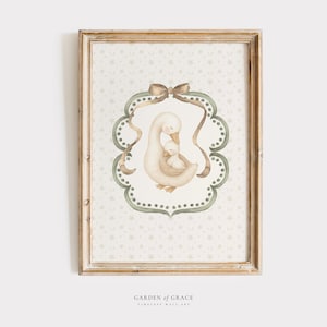 May include: A framed watercolor print featuring a mother goose and gosling within a decorative oval frame. The frame is light brown, and the background has a subtle floral pattern. The artwork is labeled "Garden of Grace, Timeless Wall Art."