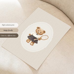 K&ouml;nnte beinhalten: Ein beige-wei&szlig; gestreifter Druck mit einer Aquarellillustration eines Teddyb&auml;ren in Tennisbekleidung, der einen Schl&auml;ger h&auml;lt. Die Illustration befindet sich in einem Oval. Der Text auf dem Druck lautet "High resolution print", "Budget friendly" und "Comes in 5 different sizes".