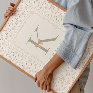 Pu&ograve; includere: Stampa floreale incorniciata con una grande lettera "K" con un fiocco rosa, su sfondo crema. La cornice &egrave; marrone chiaro. La stampa presenta un motivo floreale con rose rosa. Il nome "Kristy" &egrave; stampato verticalmente a destra.