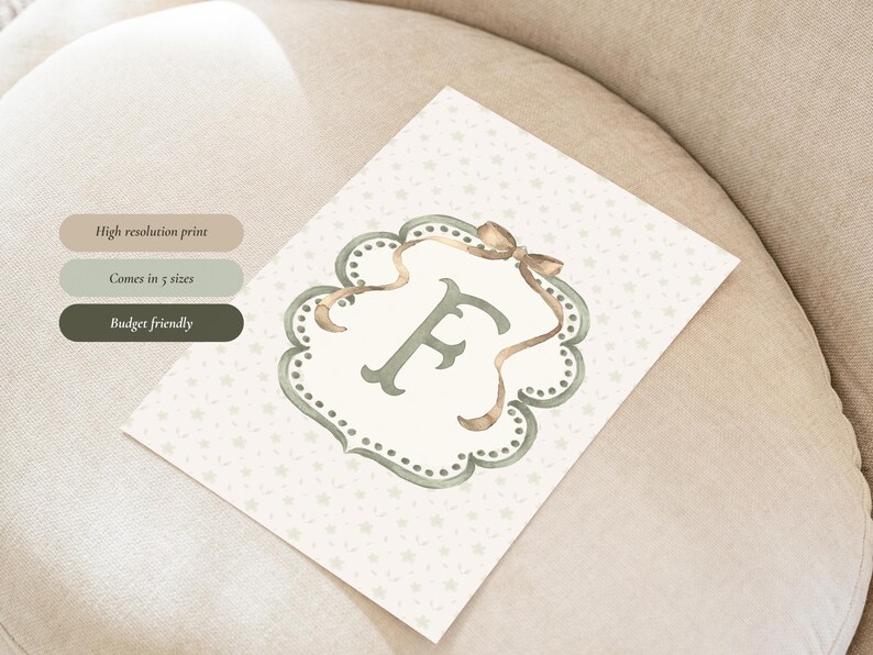 May include: A watercolor print featuring the letter "F" in a decorative frame with a bow. The print has a light background with small star patterns. Text on the left side reads "High resolution print", "Comes in 5 sizes", and "Budget friendly".