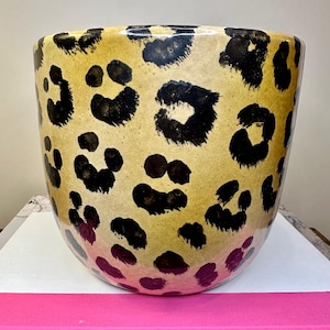 May include: A white ceramic mug with a black handle and the text "But First, Coffee" in a black, handwritten-style font. The mug is on a white surface.