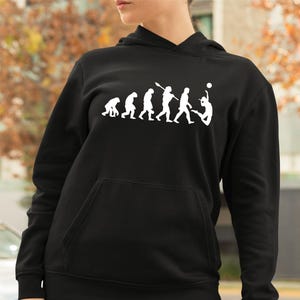 May include: Black hoodie featuring a white graphic illustrating the evolution of volleyball. The design shows a sequence of figures, culminating in a volleyball player. The hoodie includes a front pocket and a drawstring hood.