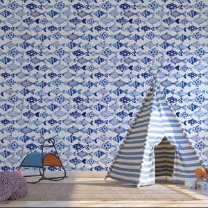 Könnte beinhalten: Eine weiße Wand mit einer blauen und weißen Fischmuster-Tapete. Im Vordergrund steht ein blaues und weiß gestreiftes Tipi-Zelt.