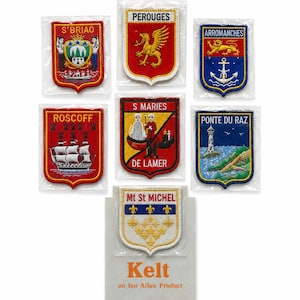 Puede incluir: Siete parches bordados en forma de escudo con ubicaciones francesas: S'BRIAO, PEROUGES, ARROMANCHES, ROSCOFF, S MARIES DE LAMER, PONTE DU RAZ y Mt St MICHEL. Cada parche muestra diseños heráldicos o escénicos únicos en colores vibrantes.