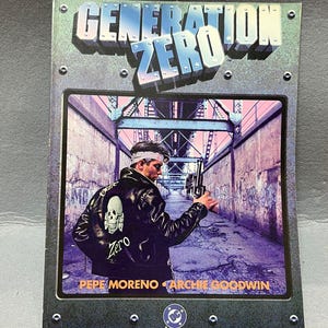 Puede incluir: Portada de cómic de Generation Zero. Muestra a un hombre con una chaqueta de cuero negra sosteniendo un arma, con una calavera y la palabra "Zero" en la espalda. El fondo muestra un túnel con grafitis. El título está en plata y azul.