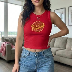 May include: A red vest top with a circular yellow and red graphic  vest top is sleeveless and has a matching graphic on the back. The items are on a bed of straw.