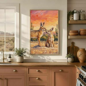 May include: A rectangular wall art print featuring an oil painting of two foxes in a desert landscape. One fox stands while the other sits on a rocky outcrop. The background displays tall cacti under a vibrant orange and pink sunset sky.