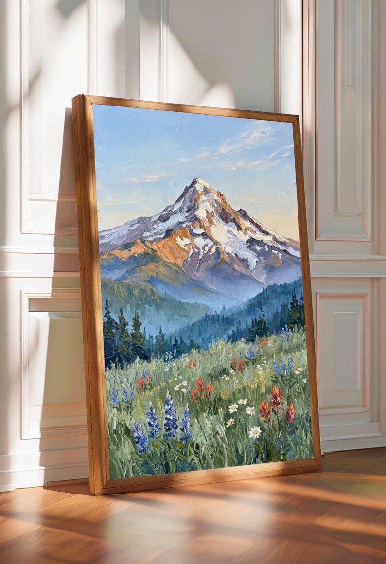 Pu&ograve; includere: Un dipinto a olio incorniciato verticalmente che raffigura una cima di montagna innevata che sovrasta una fitta foresta di pini verde scuro. Il primo piano presenta un prato vivace pieno di lupini blu, pennelli indiani rossi e margherite bianche.