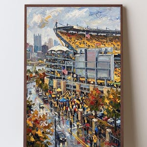 Peut inclure: Une peinture à l'huile représentant un stade aux sièges jaunes, entouré par une ligne d'horizon urbaine. La scène inclut une foule marchant dans une rue en contrebas, des arbres au feuillage automnal et un grand tableau d'affichage dans un cadre brun.