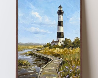 May include: An oil painting in a brown frame depicting a tall, black and white striped lighthouse standing near a wooden boardwalk that winds through a marshy landscape with tall grasses, purple wildflowers, and a light blue sky with clouds.