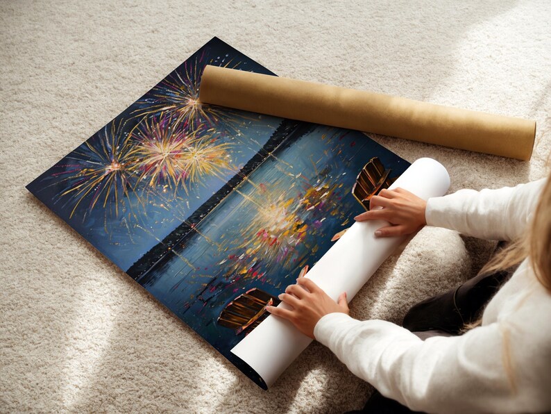 May include: A rectangular art print featuring a dark night sky filled with vibrant, multi-colored fireworks exploding above a calm body of water. The scene includes reflections of the light on the water surface and a brown cardboard shipping tube.