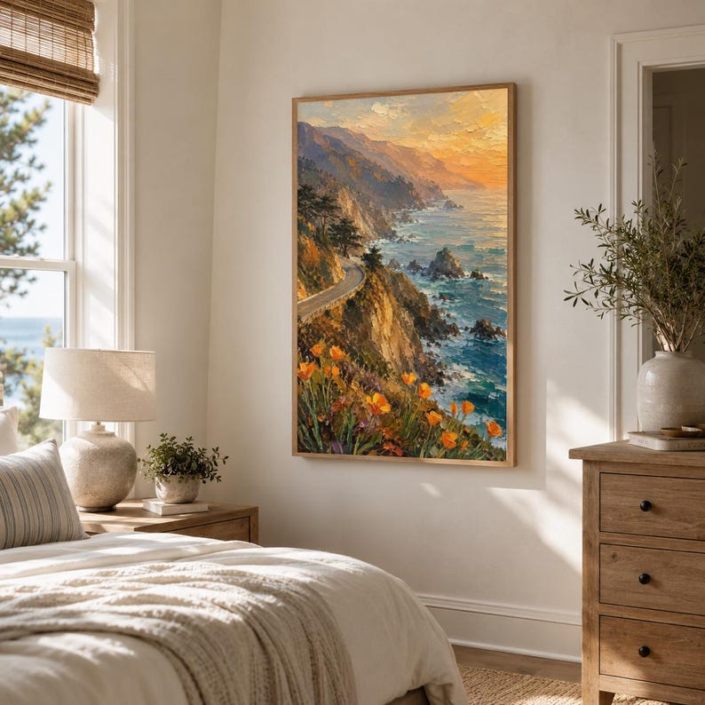 May include: A framed landscape painting depicts a coastal scene with a winding road, cliffs, and ocean. The artwork features vibrant colors, including orange flowers, blue water, and a sunset sky. The painting is displayed in a bedroom setting.