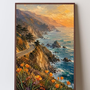 May include: A framed landscape painting depicts a coastal scene with a winding road, cliffs, and ocean. The artwork features a warm color palette with orange flowers in the foreground and a sunset in the background. The painting is in a dark brown frame.