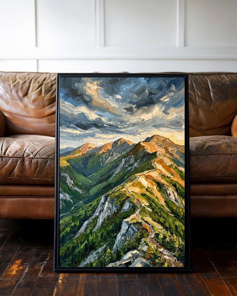 May include: A vertical oil painting in a black frame depicting a mountain range with thick, textured brushstrokes. The scene features green slopes, rocky ridges illuminated by golden light, and a dramatic, swirling sky with dark blue and grey clouds.