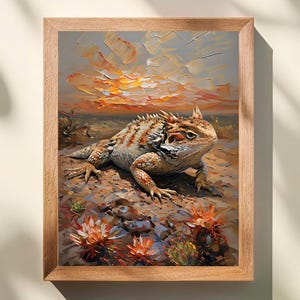 以下が含まれることがあります： 砂漠の風景の中にいる角トカゲを描いた額装された油絵。トカゲは、日焼け色とオレンジ色の質感のある棘のような鱗を持っています。背景には、厚く目に見える筆致で描かれた夕日と、オレンジ色の砂漠の花が描かれています。