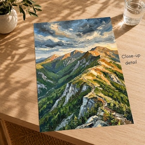 May include: An oil painting on canvas depicting a mountain range with green slopes, rocky ridges, and golden sunlight hitting the peaks under a dark, cloudy sky. The text Close-up detail is printed on the right side of the artwork.