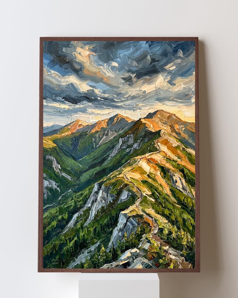 May include: An oil painting on canvas featuring a mountain range with thick, textured brushstrokes. The scene displays green slopes, rocky ridges, and a dramatic sky with dark blue and golden clouds. The artwork is framed in a dark brown wood frame.