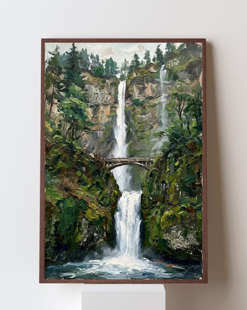 Pu&ograve; includere: Un dipinto a olio in una cornice di legno scuro raffigurante una cascata a due livelli che scende lungo una parete rocciosa. Un ponte in pietra attraversa lo spazio tra le scogliere sopra la cascata inferiore, circondato da fitti pini.