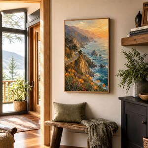 May include: A framed landscape painting depicts a coastal scene with a winding road, cliffs, and ocean. The artwork features vibrant colors, including orange flowers, blue water, and a sunset sky. The painting is displayed in a room with a wooden bench and a green pillow.
