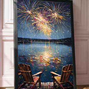 May include: A framed vertical wall art print depicting two wooden chairs on a dock overlooking a dark blue lake at night. Above the water, vibrant yellow and orange fireworks explode in the sky, with their light reflecting on the rippling surface.